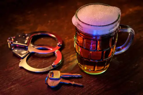 mug of beer, car keys, and hand cuffs