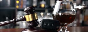 Picture of an alcoholic drink next to car key fob and gavel