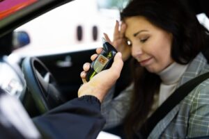 A police officer giving a woman a breathalyzer test