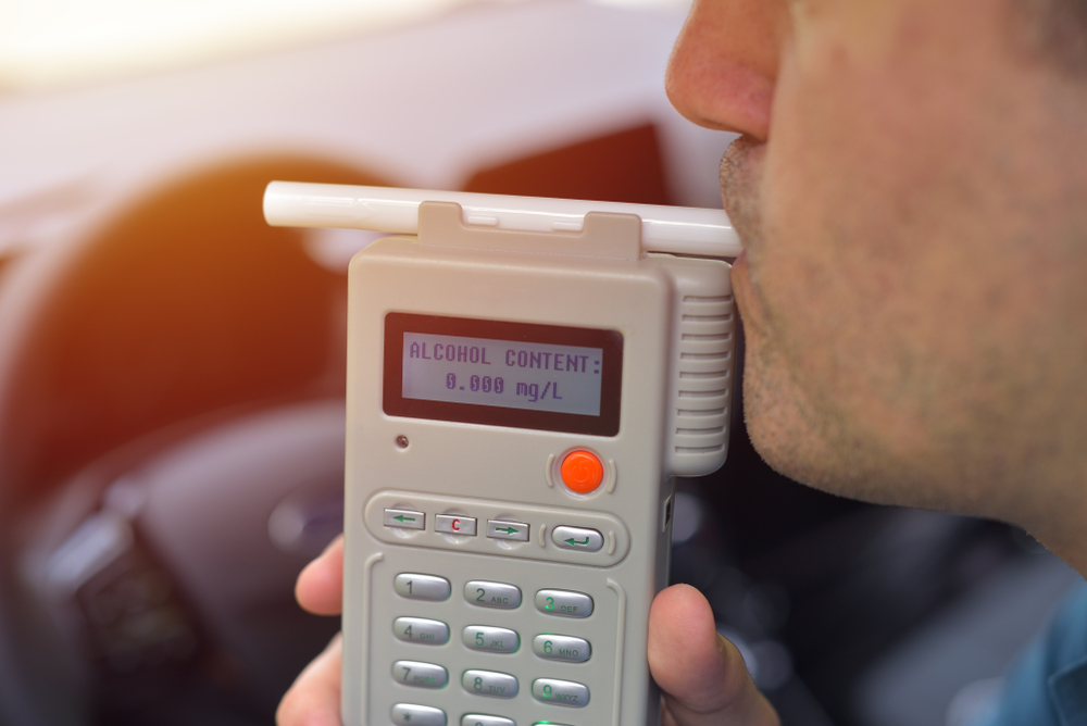 Man blowing into a breathalyzer