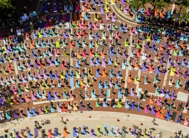 crowd doing yoga in plaza